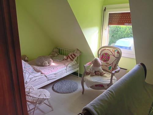 um quarto para crianças com uma cama e cadeiras e uma janela em Chambre d'hôtes La Montjoie em La Souris