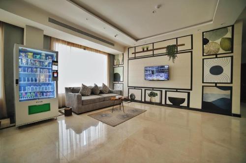 uma sala de estar com um sofá e um grande ecrã em توجاردن طابه - Tu jardin Tabba em Sulţānah