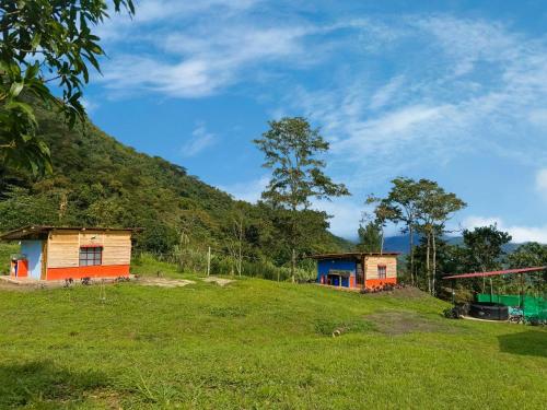 two houses on a hill with a green field at Glamping eco descanso la vega Nocaima in Nocaima