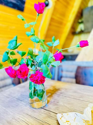 a vase filled with red roses sitting on a table at Eco cottage sunrise merisi in Merisi