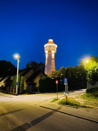 a lighthouse in the middle of a street at night at Apartamenty pod Wieżą 1 in Olsztynek
