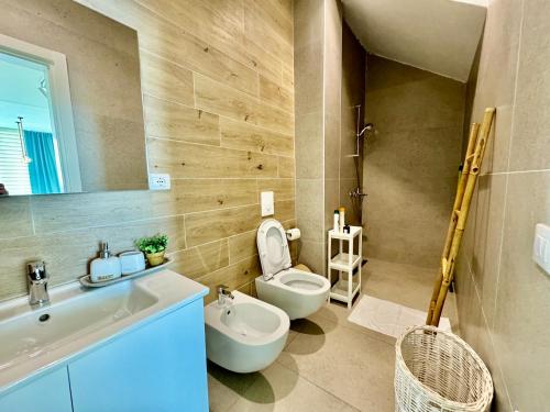 a bathroom with a toilet and a sink and a tub at Green Coast, Palase 148 in Palasë