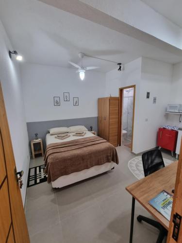 a bedroom with a bed and a desk and a table at Studio fantástico in São Paulo