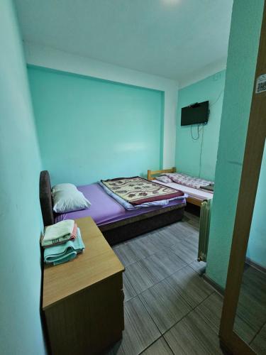 a room with two beds and a desk and a tv at Guesthouse Meče in Bijelo Polje