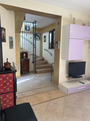 een woonkamer met een tv en een trap bij Villa Silvia in Fontana Liri Inferiore