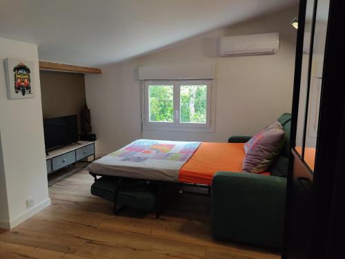 une chambre avec un lit, une fenêtre et un canapé dans l'établissement Studio dans la forêt provençale, à Jouques