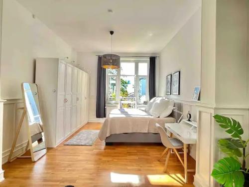 a bedroom with a bed and a desk and a table at Jugendstil-Appartement mit Terrasse und Balkon in Siegburg