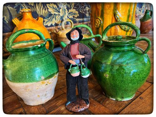 a figurine of a person standing next to two green vases at La Providence in Apt