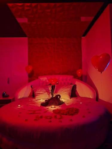 une femme allongée sur un lit dans une chambre rouge dans l'établissement Logement Romantique Jacuzzi spa, à Vieille-Toulouse