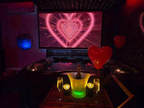 a room with a tv with a heart on the screen at Logement Romantique Jacuzzi spa in Vieille-Toulouse