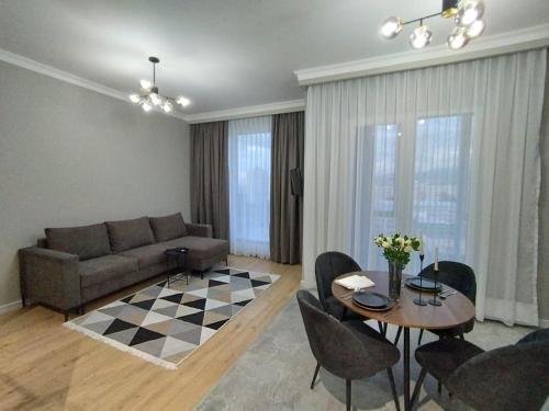 salon z kanapą, stołem i krzesłami w obiekcie Like Home Hostel na Shevchenko, 162Б w mieście Ałma-Ata