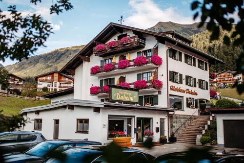 a large white building with flowers on it at Gästehaus Daheim in Riezlern