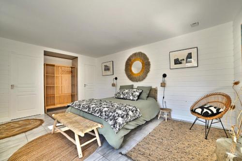 une chambre avec un lit et un miroir au mur dans l'établissement Hirondelles et Abeille, à La Tremblade