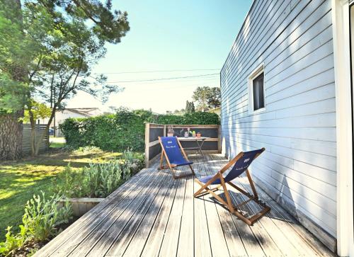 2 chaises assises sur une terrasse à côté d'une maison dans l'établissement Hirondelles et Abeille, à La Tremblade