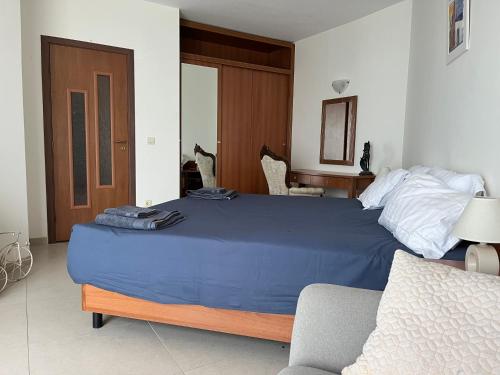 a bedroom with a large bed with a blue blanket at Privat apartament Golf Coast in Kavarna