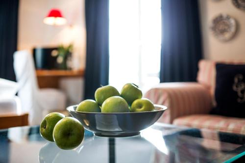 a bowl of green apples on a glass table at Gästehaus Daheim in Riezlern