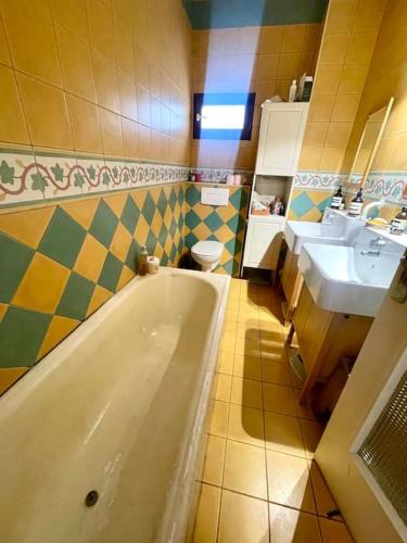 une salle de bain avec deux lavabos et une baignoire dans l'établissement Grande maison de 170m2, piscine, grand jardin fleuri- 5ch - très calme, proche de Paris (metro ligne 7), à Vitry-sur-Seine
