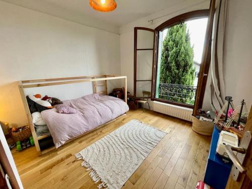 une chambre avec un lit et une grande fenêtre dans l'établissement Grande maison de 170m2, piscine, grand jardin fleuri- 5ch - très calme, proche de Paris (metro ligne 7), à Vitry-sur-Seine
