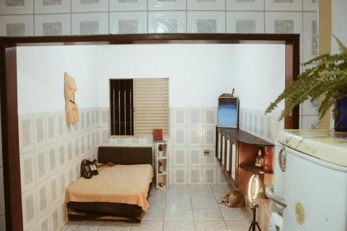 ein Zimmer mit einem Bett und einem großen Bildschirm in der Unterkunft Casa inteira no maior São João do Brasil! in São José de Ribamar
