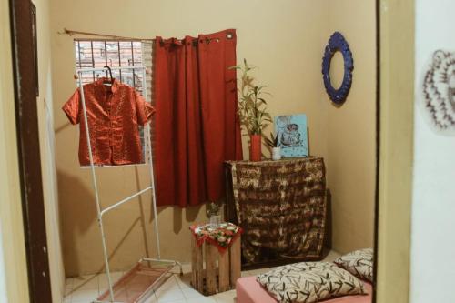 einen Spiegel in einem Zimmer mit einem Hemd auf einem Kleiderständer in der Unterkunft Casa inteira no maior São João do Brasil! in São José de Ribamar