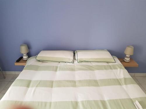 un lit avec deux oreillers dessus dans une chambre dans l'établissement Confortable 2P 50m2 dans Beau Parc,Piscine,Tennis, à Cannes