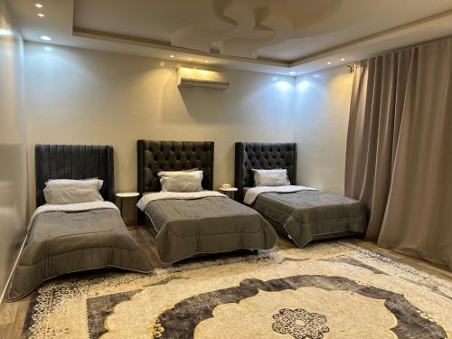 a bedroom with two beds and a rug at شقق العارض (2) in Riyadh