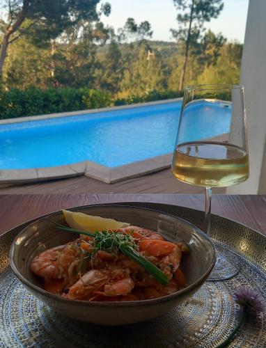 a bowl of food and a glass of wine on a table at The Space - Central Portugal in Fungalvaz