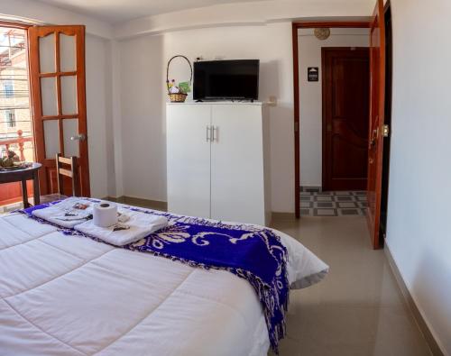 a bedroom with a bed with a tv on top of it at ValMas H in Chachapoyas