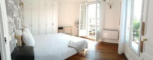 une chambre blanche avec un lit et une fenêtre dans l'établissement A 18 min de Notre Dame au cœur de Paris en RER C, à Ivry-sur-Seine