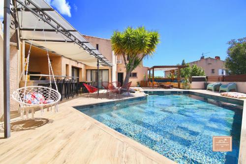 a swimming pool with a swing and a house at Villa Kaz des sables in La Seyne-sur-Mer