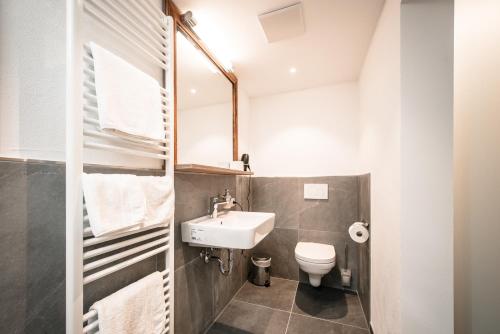 a small bathroom with a sink and a toilet at Hotel Tradizio in Mittelberg