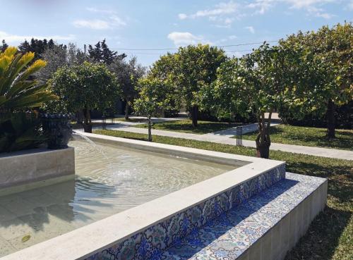 a fountain in a park with trees in the background at Villa Felicia in Noto