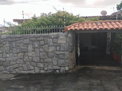 ein Steingebäude mit einem Tor und einer Steinmauer in der Unterkunft CASA 2024 - São João Campina Grande/PB in Campina Grande