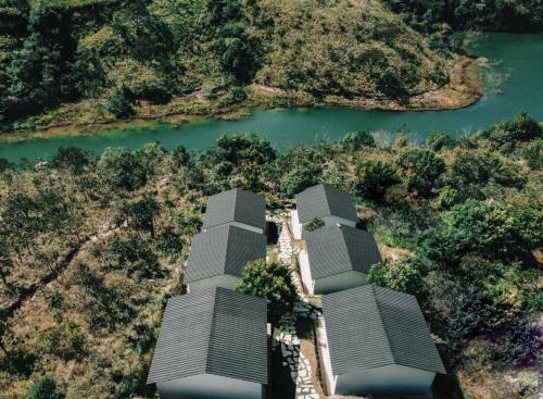 una vista aerea di tre edifici alti vicino a un fiume di Casa Physis a Capitólio