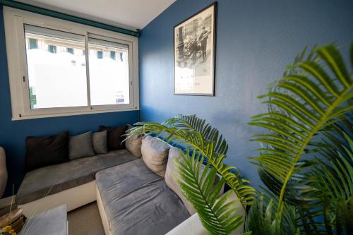 un salon avec un canapé et une plante dans l'établissement La Belle Etape * Puy du Fou * Proche Commerces, à Cholet