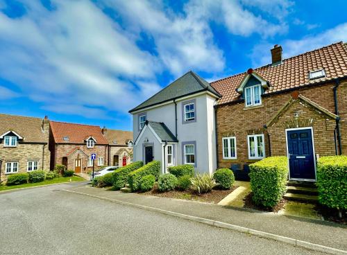 a house with a blue door on a street at Jolly Roger Cottage - Part of the The Bay Filey Holiday Village with pool, gym and direct beach access, pub, restaurant, tennis and meadows walks in Filey