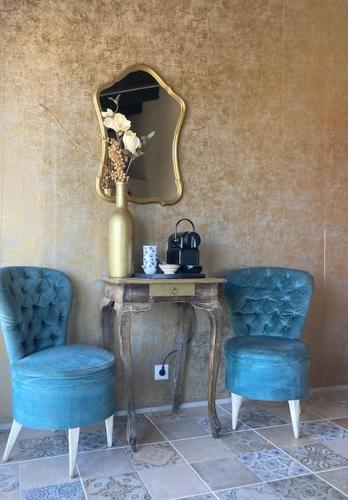 two blue chairs sitting next to a table with a mirror at Villa Torre, Valencia Spanje in Macastre