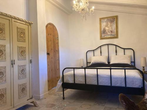 a bedroom with a bed and a chandelier at Villa Torre, Valencia Spanje in Macastre