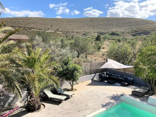 a villa with a swimming pool and palm trees at Villa Torre, Valencia Spanje in Macastre