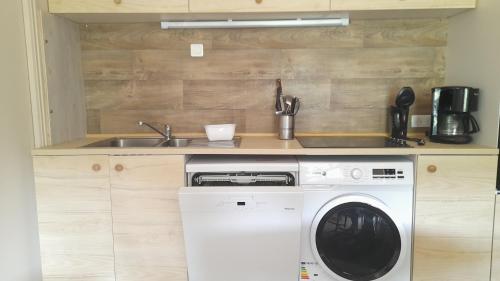 une cuisine avec une machine à laver et un évier dans l'établissement Gîte dans le Cantal dans la vallée de la Maronne, à Saint-Martin-Valmeroux