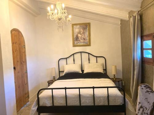 a bedroom with a bed and a chandelier at Villa Torre, Valencia Spanje in Macastre