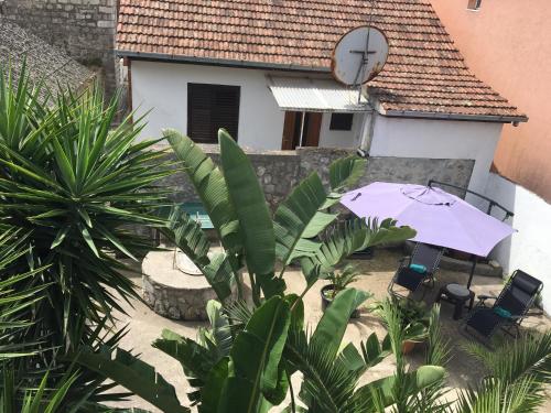 an umbrella and chairs in front of a house at Apartments Lilly in Ðenovići