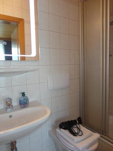 Un baño blanco con lavabo y espejo. en Ferienwohnung Fuchs, en Bad Mitterndorf