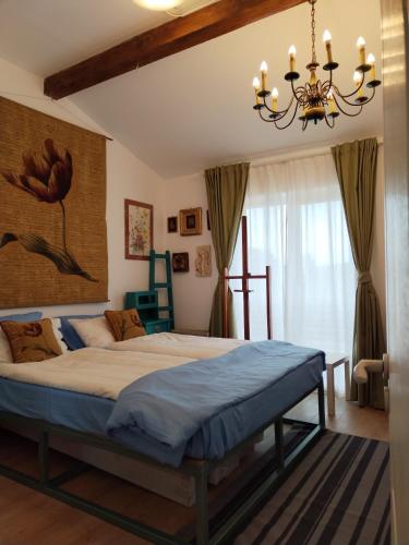 a bedroom with a large bed with a chandelier at Retreat House Herneacova in Herneacova
