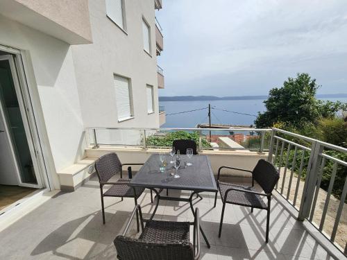 a patio with a table and chairs on a balcony at Apartments Majic Zivogosce in Živogošće