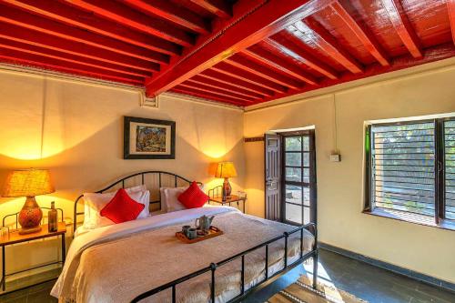 a bedroom with a large bed with red beams at Private & Scenic Serene 2BR Villa in Dharamshala in Dharamshala