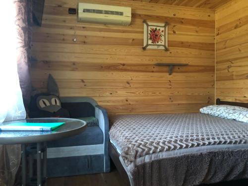 sypialnia z łóżkiem w drewnianej ścianie w obiekcie Казковий Світязь w mieście Szack