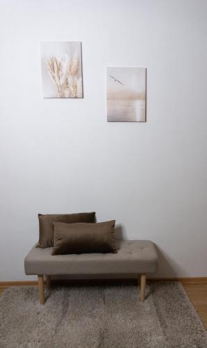 a couch in a room with two pictures on the wall at (W)einHaus am See in Rust