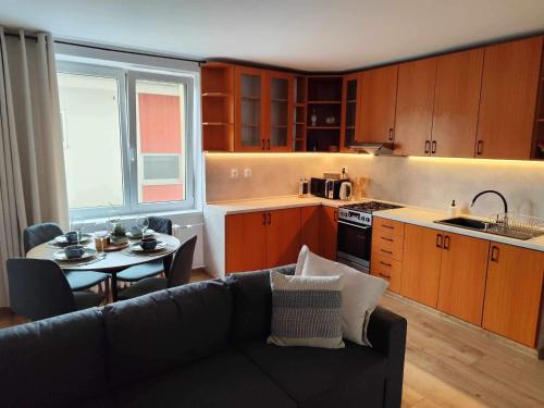 a living room with a couch and a table in a kitchen at Centrum Poprad Apartment in Poprad