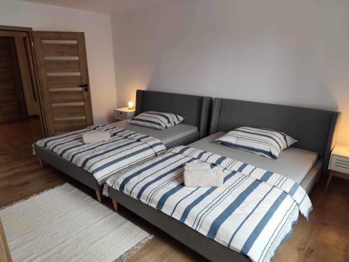 a bedroom with two beds with striped pillows at Centrum Poprad Apartment in Poprad